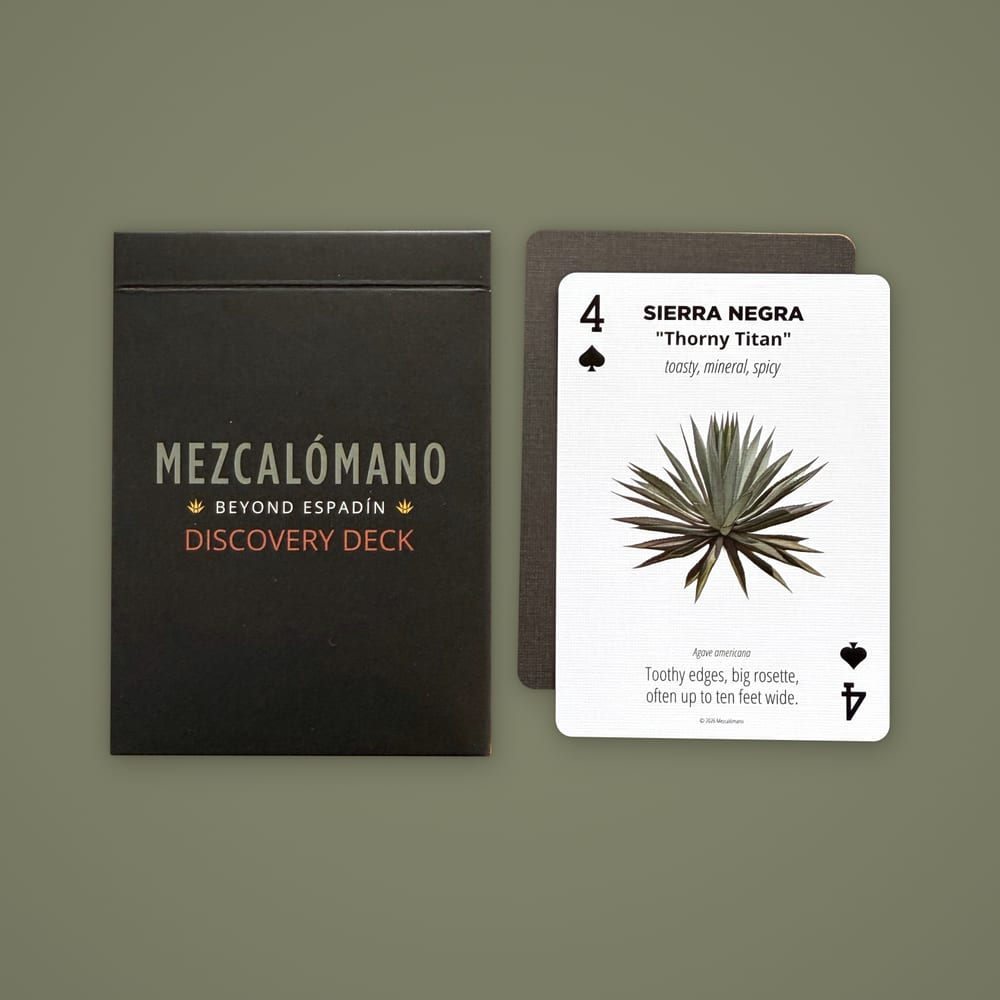 The Discovery Deck box beside the Sierra Negra card and a card back on an olive green background.