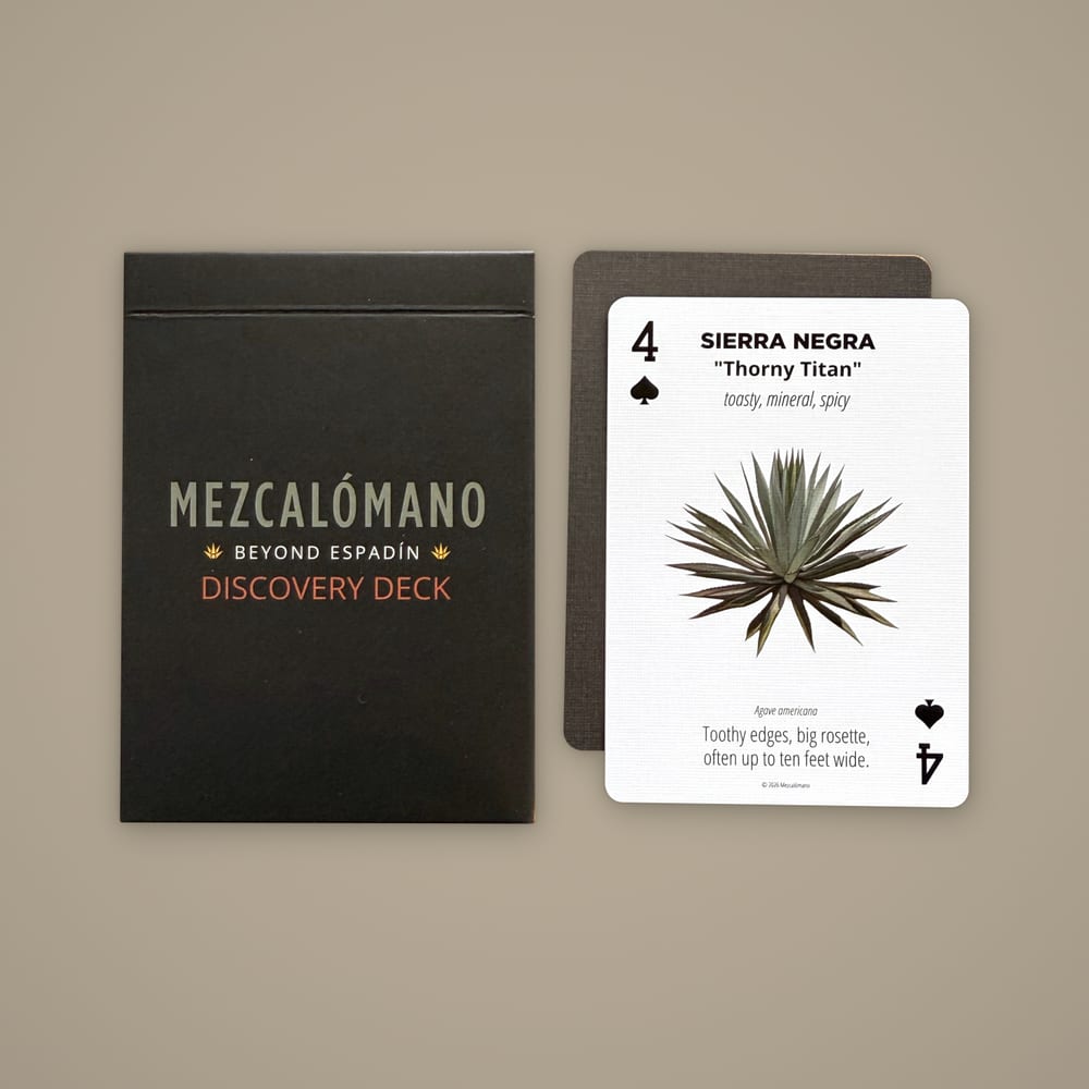 The Discovery Deck box beside the Sierra Negra card and a card back on a warm stone background.